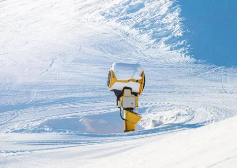Snow making machine at a ski resort on a sunny winters day. Stock Photos