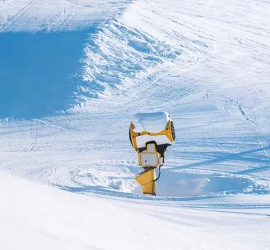 Snow making machine at a ski resort on a sunny winters day. Stock Photos