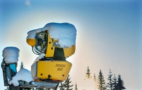 Snow making machine at a ski resort on a sunny winters day. Stock Photos