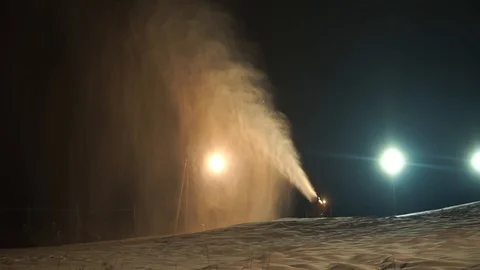 Snow making system. A snow cannon sprays water and makes snow. A lantern shines Stock Footage 124277548
