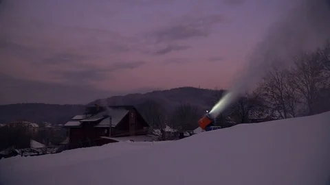 Snow making system. A snow cannon sprays water and makes snow. On sunrise, the Stock Footage 124277574