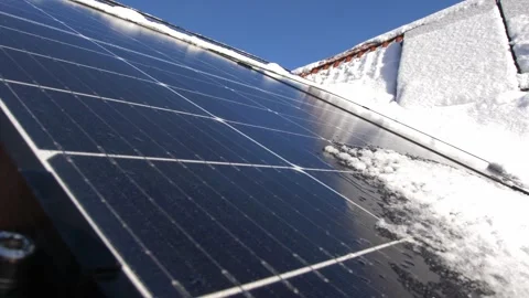 Snow Melting on PV Solar Panels Located on Private House Roof on Sunny Day Stock Footage 259184493
