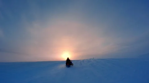 Snow mobile drive fast to the large low Sun in frosty cold foggy winter sky.. Stock Footage 253911488