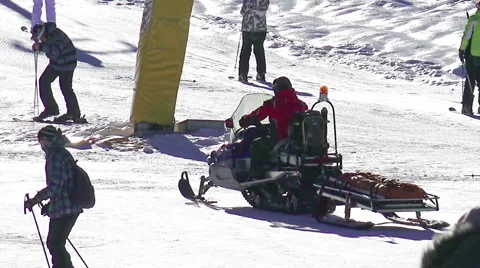 Snow mobile first aid emergency help service rides to rescue skier Stock Footage 61240221