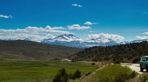 Snow Mountain and Clouds Formation by the Road Stock Footage 24972378