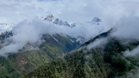 Snow Mountain Scenery. Snowcapped Summits Beneath Clouds Displaying Icy Slopes 库存影片 339175247