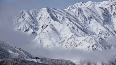 Snow mountains with clouds and mist is beautiful landscape by time-lapse Stock Footage 149976556