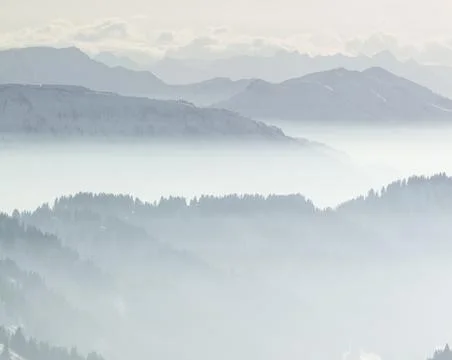 Snow Mountains in low lying inversion valley fog. Silhouettes of foggy Mountains Stock Photos