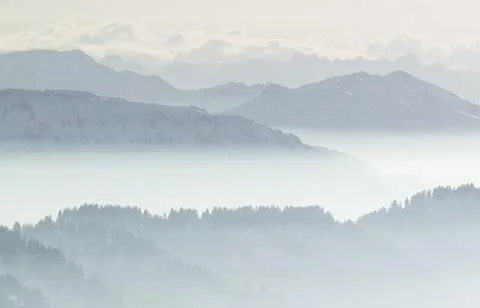 Snow Mountains in low lying inversion valley fog. Silhouettes of foggy Mountains Stock Photos