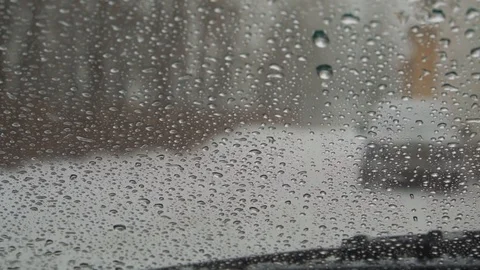 Snow outside the window turns into drops of water on the glass of the car. We ob Video stock 100010482