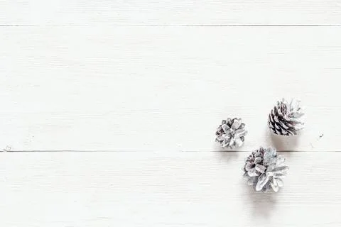 Snow painted pine cones on rustic white wood table. Christmas decoration back Stock Photos