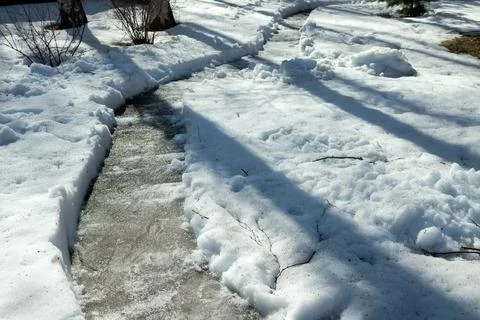 Snow path in the garden in spring. Clean the garden path Stock Photos