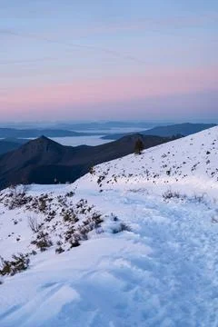 Snow path winding through mountains at dawn Stock Photos