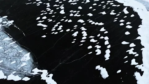 Snow patterns on dark water create striking natural art Stock Footage 320293529