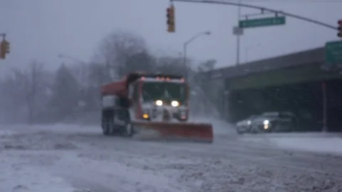 Snow plow crossing city intersection during heavy snowstorm Stock Footage 73675168