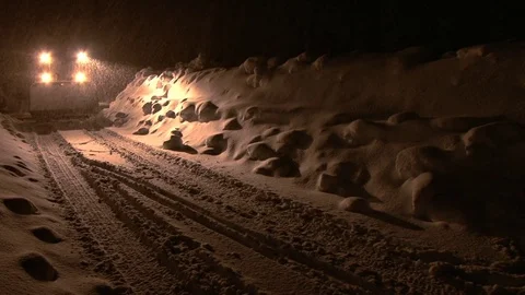 Snow plow moves down road at night during snowstorm Stock Footage 74095444