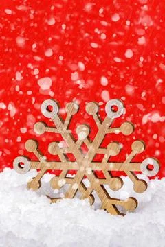 Snow on a red background, snowfall or falling snow. Large wooden snowflake in Stock Photos