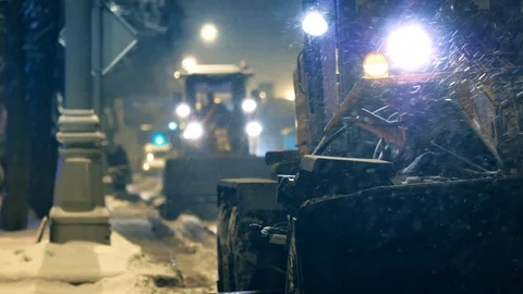 Snow removal machines working on winter city street night during heavy snowfall Vidéo 120821788