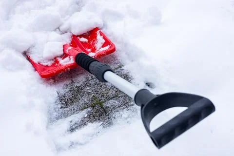 Snow removal in winter, Snowfall, Red shovel lying in the snow. Seasonal  Stock Photos