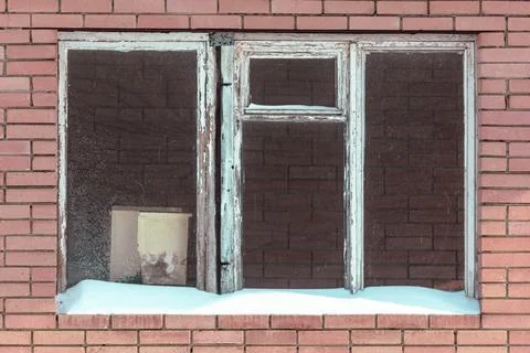 Snow rests on a weathered window frame Stock Photos