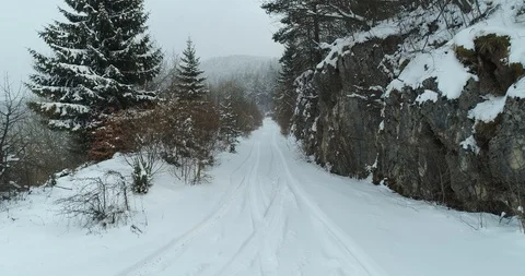 Snow road trough forest in winter on mountain Stock Footage