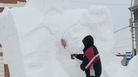Snow sculptures, making. The master makes a figure out of snow. Stock-Footage 122362451