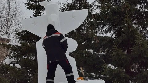 Snow sculptures, making. The master makes a figure out of snow. Stock-Footage 122362466