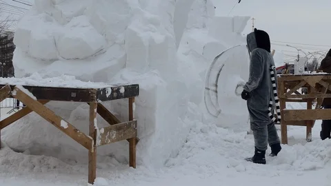 Snow sculptures, making. The master makes a figure out of snow. Video stock 122362549