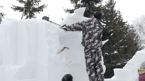 Snow sculptures, making. The master makes a figure out of snow. Stock-Footage 122362603