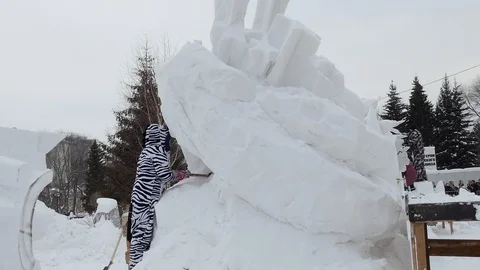 Snow sculptures, making. The master makes a figure out of snow. Stock-Footage 122362675
