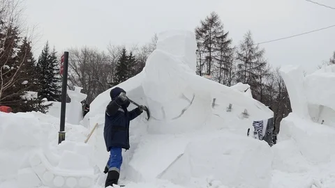 Snow sculptures, making. The master makes a figure out of snow. Video stock 122362712
