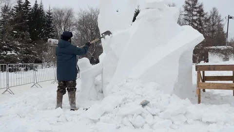 Snow sculptures, making. The master makes a figure out of snow. Video stock 122362741