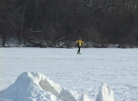 Snow serpent ice carving on frozen lake, widens fr cu skier Stock Footage 221091153