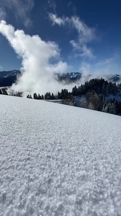 Snow sparkles in the sun like thousands of diamonds. White clouds float in the Stock Footage 289025205