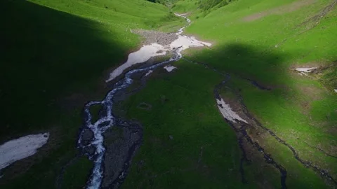 Snow Speckled River Winding Through Greenery Stock Footage 256180747