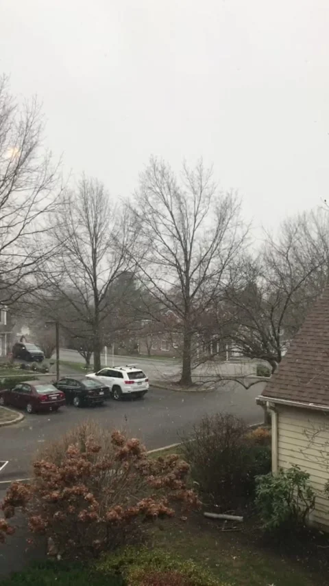Snow start to fall in a quiet suburban neighborhood Stock Footage 144841903