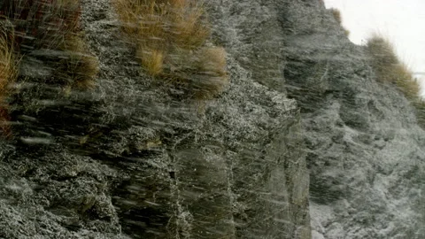 Snow storm agains rock cliffs in alpine New Zealand Stock Footage 159707192