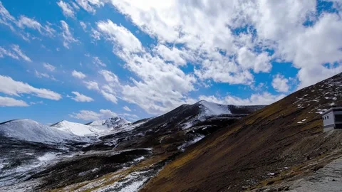 Snow striped ridge and small building on a Tibetan mountainside Vidéo 345882799