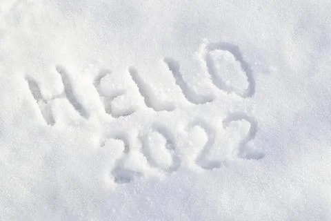 Snow surface and text Hello 2022. Inscription draw on white snow Stock Photos