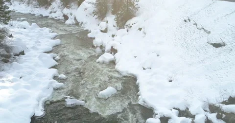 Snow surrounding a river in winter Stock Footage 283257598