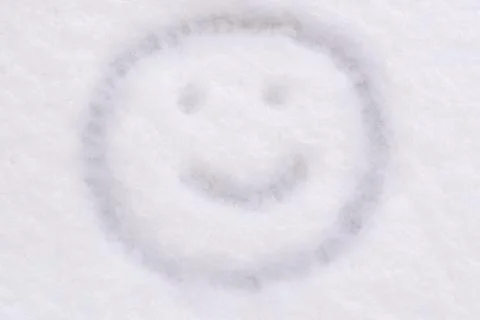 Snow texture close-up smiley face is drawn Stock Photos