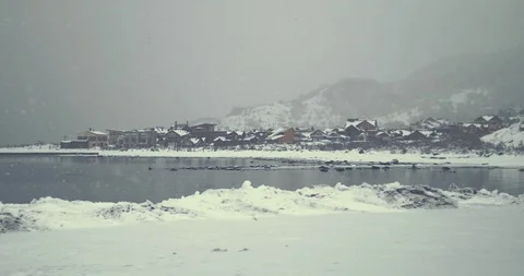 Snow town view from a coast through a lake. Stock Footage 129853970