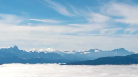 Snow-white clouds blue sky and peaks covered with white snow and fog Stock Footage 254726857