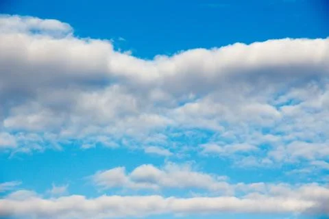 Snow-white light cumulus clouds against a blue sky Stock Photos
