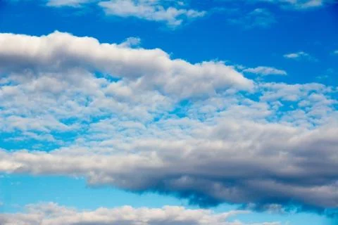 Snow-white light cumulus clouds against a blue sky Stock Photos