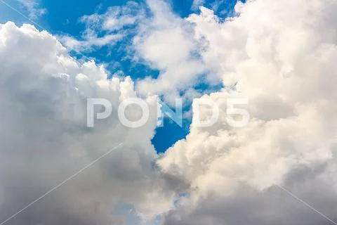 Snow-white light cumulus clouds against a blue sky Stock Photos
