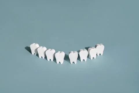Snow-white perfect models of teeth in a row on a blue background Stock Photos