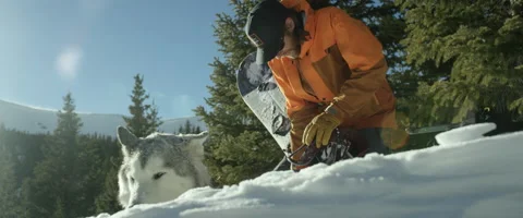 Snowboarder adjusting a snowboard Stock Footage 68497624