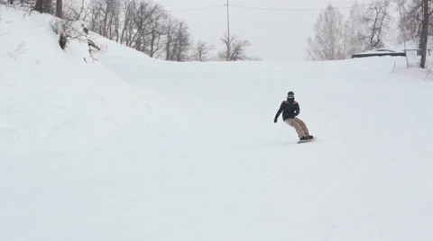 Snowboarder carves while snowboarding down a slope 스톡 동영상 59711816