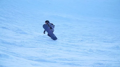 A snowboarder climbing a mountainside Stock Footage